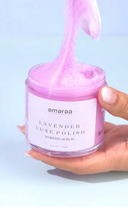 Hand holding Amaraa Fragrances Lavender Luxe Polish whipped scrub in a clear jar